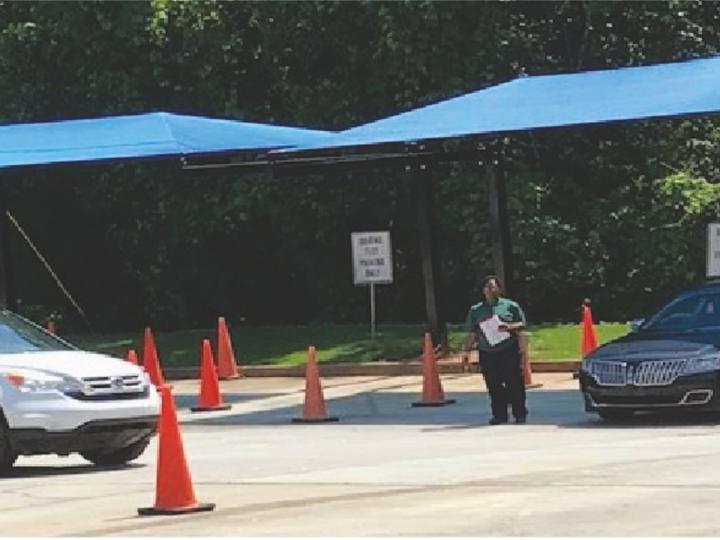 Driving test in progress, orange cones on the road with an instructor directing cars