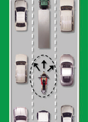 Motorcyclist is surrounded on all sides by vehicles