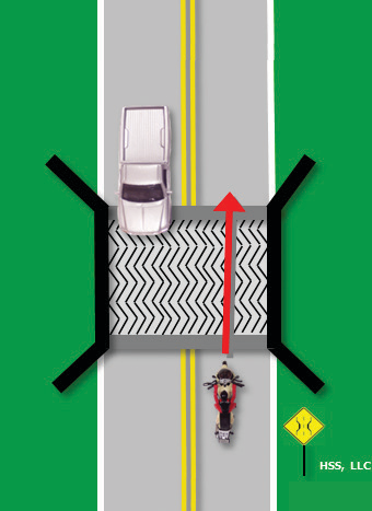 The motorcyclist drives straight across the grating