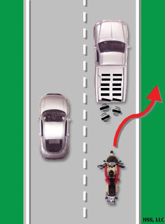 The motocyclist swerves to avoid debris falling off a car in front of them