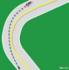 The motorcyclist begins the curve near the outside of the curve, and moves towards the inside as they pass the center