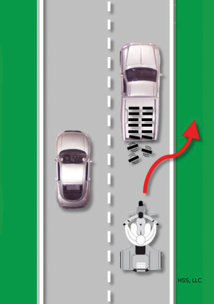 The trike brakes, then swerves to avoid debris falling off a truck