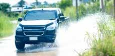 An SUV driving through a puddle