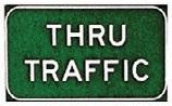 A green, horizontal rectangular Thru Traffic sign