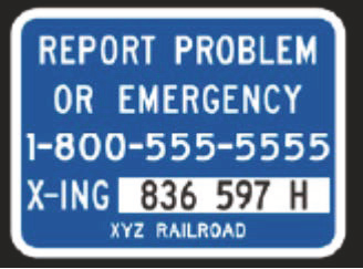 Sign reading "Report Problem or Emergency. 1-800-555-5555. X-ing 836 597 H. XYZ Railroad.