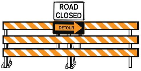 A white and yellow striped barricade with the signs "Road Closed" and "Detour".