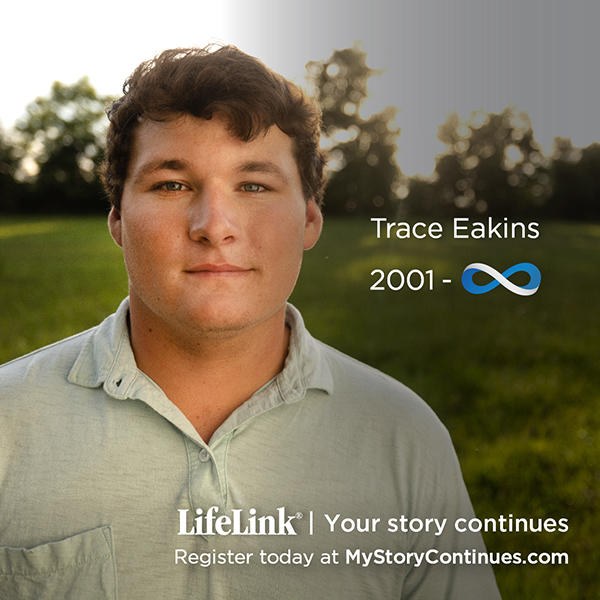 A Caucasian male facing the camera in a green field with his name, Trace Eakins, displayed above the LifeLink logo and the words "your story continues, register today at mystorycontinues.com"