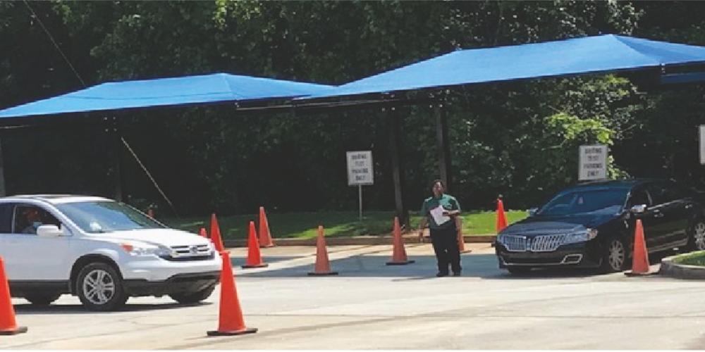 Driving test in progress, orange cones on the road with an instructor directing cars